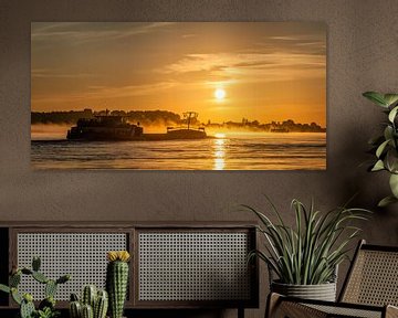 Panorama: Ein Schiff auf dem Fluss Waal mit aufgehenden Sonne