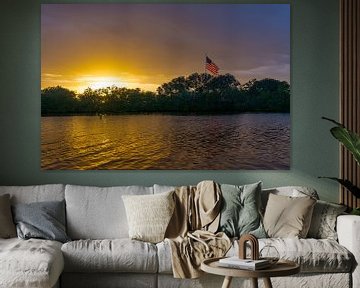 USA, Florida, Fantastische oranje zonsondergang op water, groene planten en Amerikaanse vlag met reflecties van adventure-photos