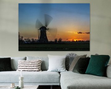 Draaiende windmolen tijdens zonsondergang