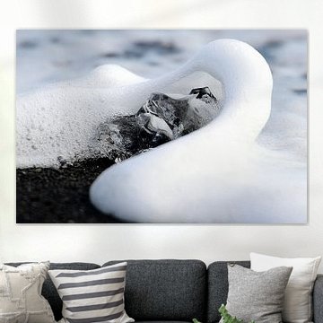 Morceau de glace avec une vague sur une plage de lave noire en Islande