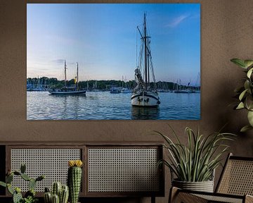 Sailing ships on the Warnow in the evening during the Hanse Sail in by Rico Ködder