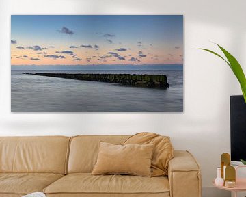 Wooden sea wall in the Wadden Sea near North Holland under a colourful sky during sunset. by Bram Lubbers