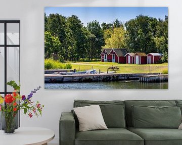 Red boathouses on Sweden's Baltic coast by Adelheid Smitt