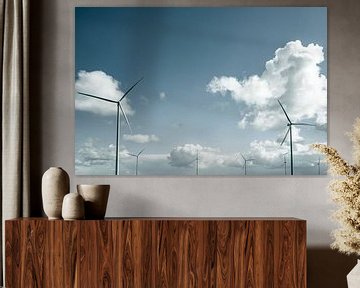 Windturbine met draaiende wieken met een stormachtige blauwe lucht in de verte van Sjoerd van der Wal Fotografie