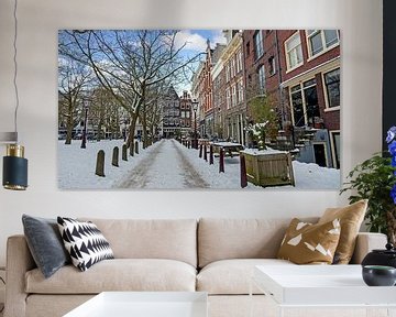 Stadsgezicht van een besneeuwd Amsterdam in de winter in Nederland van Eye on You