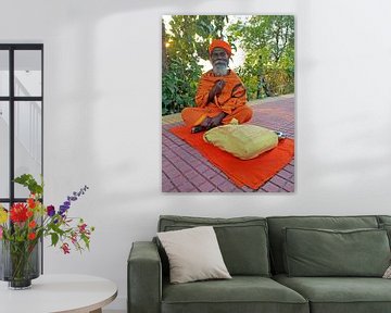 Sadhu in orange clothes sitting on the street in Tiruvanamalai Tamil Nadu India by Eye on You