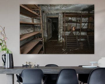 Oude stellingen met wat smeermiddel in een verlaten bunker uit WWII. van Het Onbekende