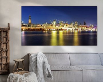 De skyline van Hamburg met het oriëntatiepunt "Michel" en het museumschip "Cap San Diego" in het blauwe uur