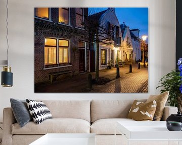 Dorpsstraatje in de avond, verlichte vensters, straatlantaarns, blauwe lucht van Jan Willem de Groot Photography