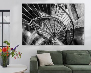 Schwarze Spindeltreppe aus Stahl mit Gitterroststufen, die sich um den Drehpunkt windet von Jan Willem de Groot Photography