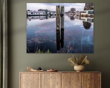 Meerpalen spiegelen bij laatste licht in blauwig water van Jan Willem de Groot Photography