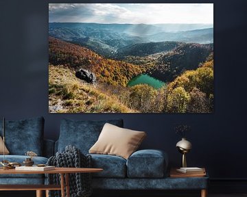 Blick auf einen Bergsee inmitten der herbstlichen Farben der Vogesen von Jos van den Berg