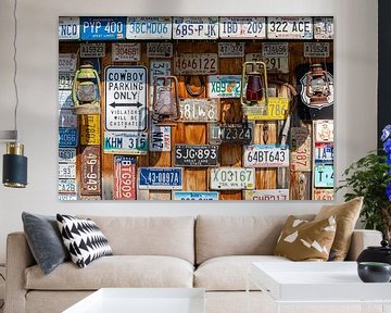 Old license plates and oil lamps on wooden wall in Canada by Inge van den Brande