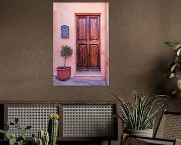 Old wooden dark lacquered door with an olive tree by Dafne Vos