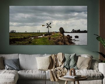 Polderlandschap met dijk, windmolen en waterpartij van Dirk Huckriede