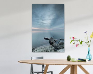 Stenen in het water van het Markermeer bij een bewolkte zonsopkomst van Bram Lubbers