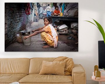Indiaas meisje doet de afwas in de achterbuurt straten van Varanasi  in India. Wout Kok One2expose van Wout Kok