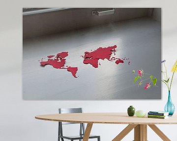 Kwetsbare aarde. Wereldkaart, uitgeknipt in rood papier, in de vensterbank van Irene Cecile
