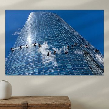 Fensterputzer hängen an einem Seil, während sie die Fenster eines gläsernen Wolkenkratzers in Buenos