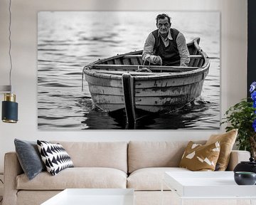 Een zwart-witfoto van een man in een boot op het meer van Animaflora PicsStock