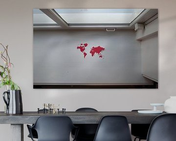 Kwetsbare aarde. Wereldkaart, uitgeknipt in rood papier, in de vensterbank