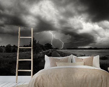 Rollende Wolken und Blitze bei der Mühle de Zwaan Vinkel in schwarz-weiß von Cynthia Verbruggen