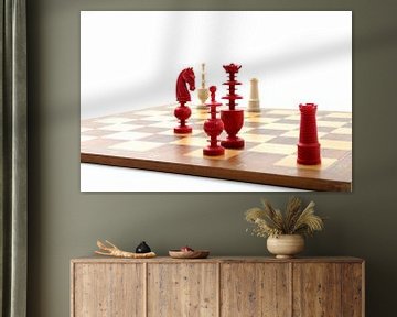Rode en witte ivoren schaakstukken op een houten bord van Wim Stolwerk