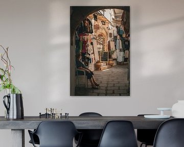 Old lady shaded for cool at a tourist shop by Patrick Vossen