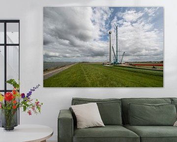 Bouw van een moderne windmolen aan de dijk in Nederland