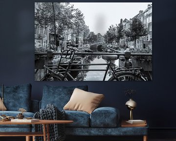 Oude fiets op een gracht in Amsterdam - monochroom van Werner Dieterich