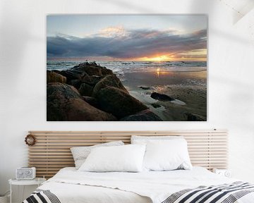 Grote stenen op het zandstrand bij zonsondergang in Denemarken