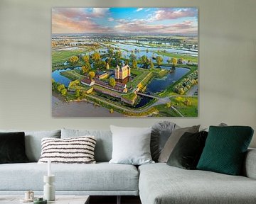 Luchtfoto van een ondergelopen landschap bij  kasteel Loevestein bij Gorinchem in Nederland bij zonsondergang van Eye on You