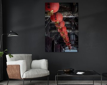 Red lanterns along the ceiling of a temple by Mickéle Godderis