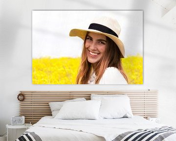 Portret van een jonge vrouw met een strohoed voor een geel bloemenveld van Anita Hermans