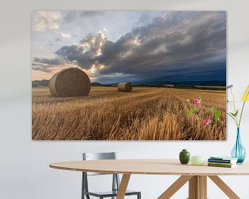 Heuballen auf dem Feld mit dramatischen Wolken von Christina Bauer Photos