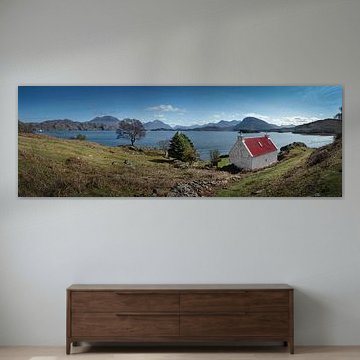 Panoramafoto von weißem Cottage mit rotem Dach am Loch Claira in den schottischen Highlands.