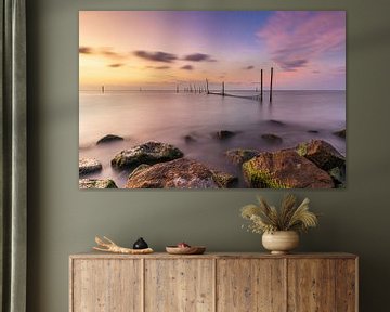 Visnetten in het IJsselmeer bij een kleurrijke rustige zonsondergang van Bram Lubbers