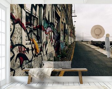 Abandoned street with graffiti and bridge in the distance - Lisbon by Dana Schoenmaker