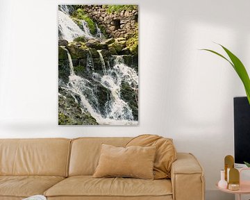 Kleine waterval in het bos met mos op stenen