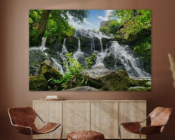 Kleine waterval in het bos met mos op stenen
