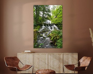 Kleine waterval in het bos met mos op stenen