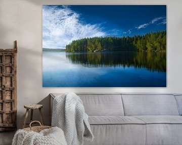 Meer in Zweden met witte wolken, blauw water en bomen aan de oever
