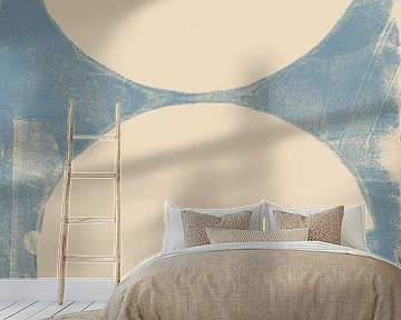 Abstract shapes in warm sand on light blue.