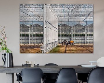 Ein im Bau befindliches Gewächshaus mit einem darin stationierten roten Traktor von Harrie Muis