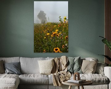 Wilde bloemen langs het weiland met aan de horizon in mist gehulde bomen van Bram Lubbers