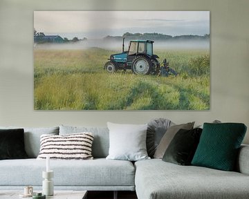 Tractor op een veld met gras van Dirk van Egmond