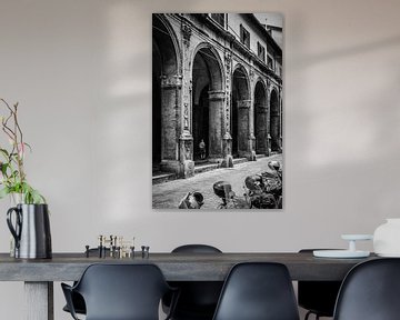 Man loopt door portici in Bologna, Italië van Rick van Geel