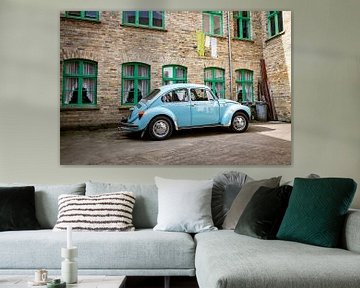 Retro blauwe klassieke auto geparkeerd naast bakstenen gebouw