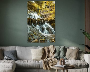 Kleine waterval in het bos met mos op stenen