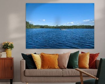 Lake in Sweden with white clouds, blue water and trees on the shore by Martin Köbsch